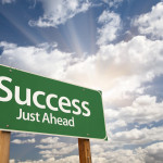 Success Green Road Sign Against Clouds